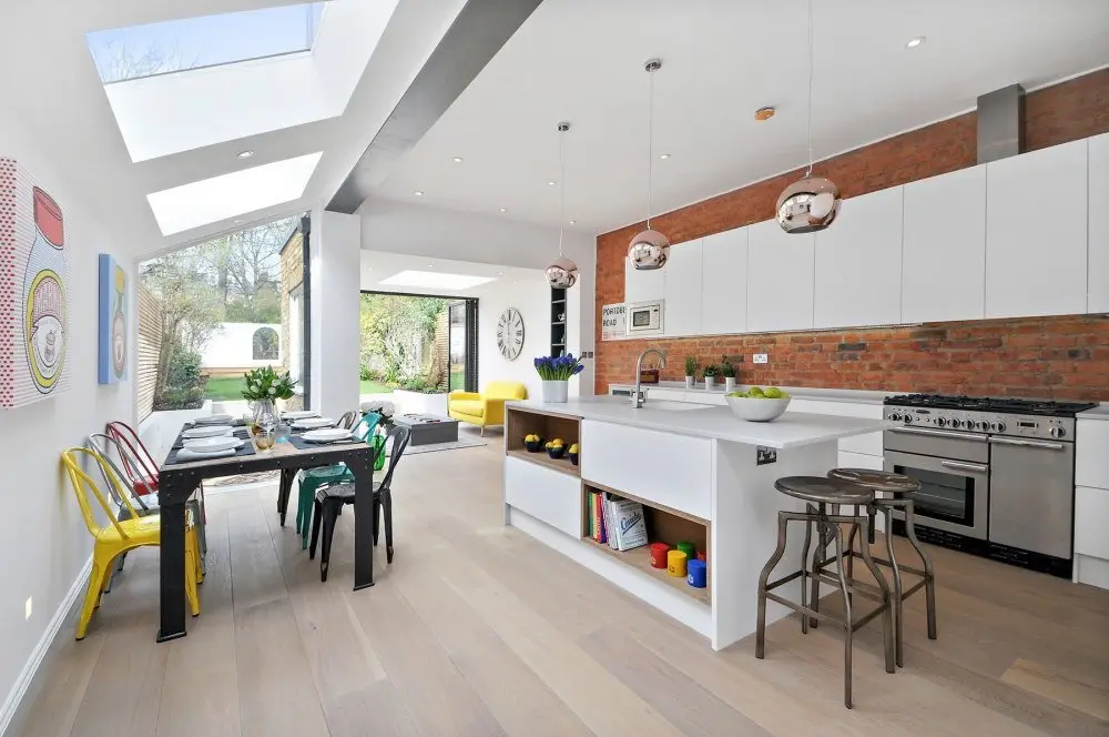 Brightly edited open-plan kitchen and dining room with a skylight