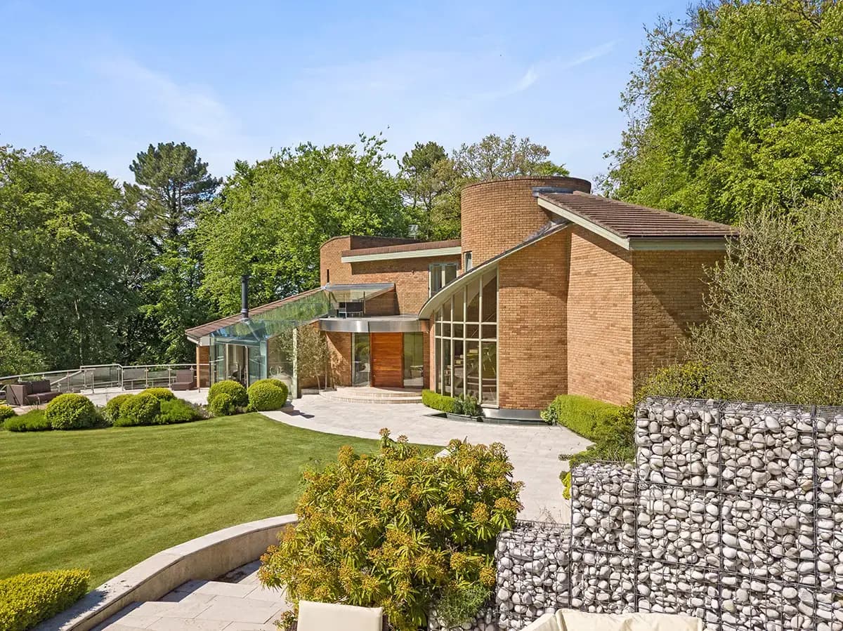 Modern property exterior with a clean driveway and landscaped garden